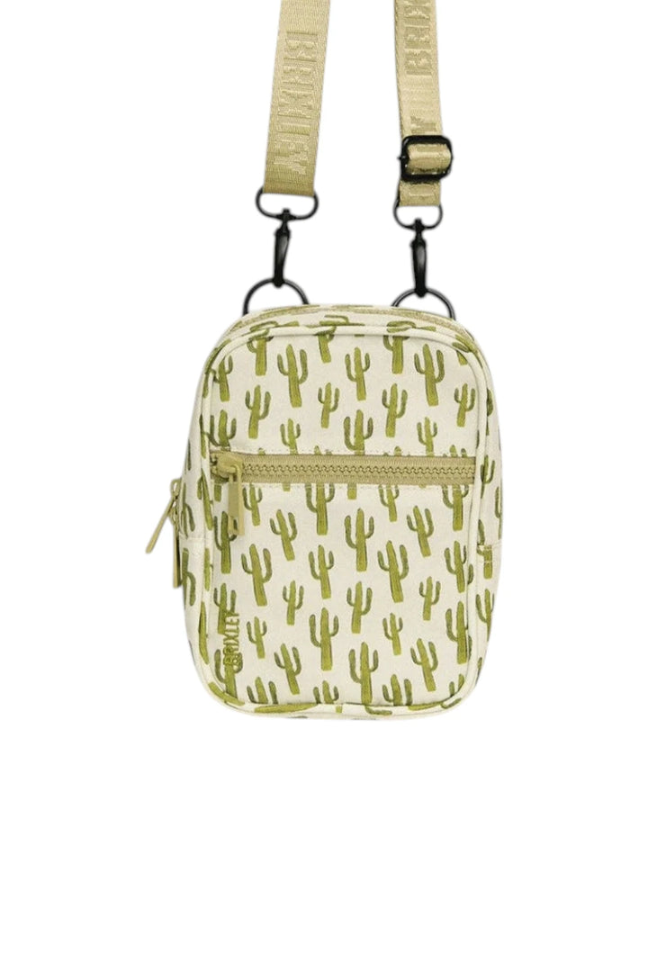A small crossbody bag with an all-over green cactus print on a cream background, featuring a matching adjustable shoulder strap and black metal hardware.