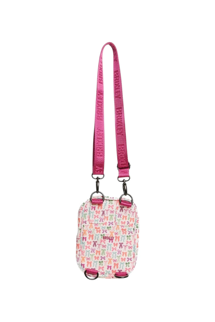 A small crossbody bag with a pink patterned body and a bright pink strap featuring black text, shown against a plain white background.
