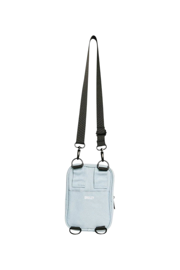 A light blue crossbody phone bag with a black adjustable shoulder strap and silver metal hardware, shown against a plain white background.