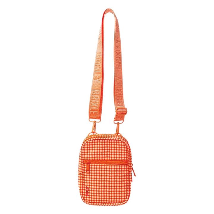 An orange and white gingham crossbody bag with a matching orange webbed strap featuring the brand name 'Brixley' repeated in white, shown against a plain white background.