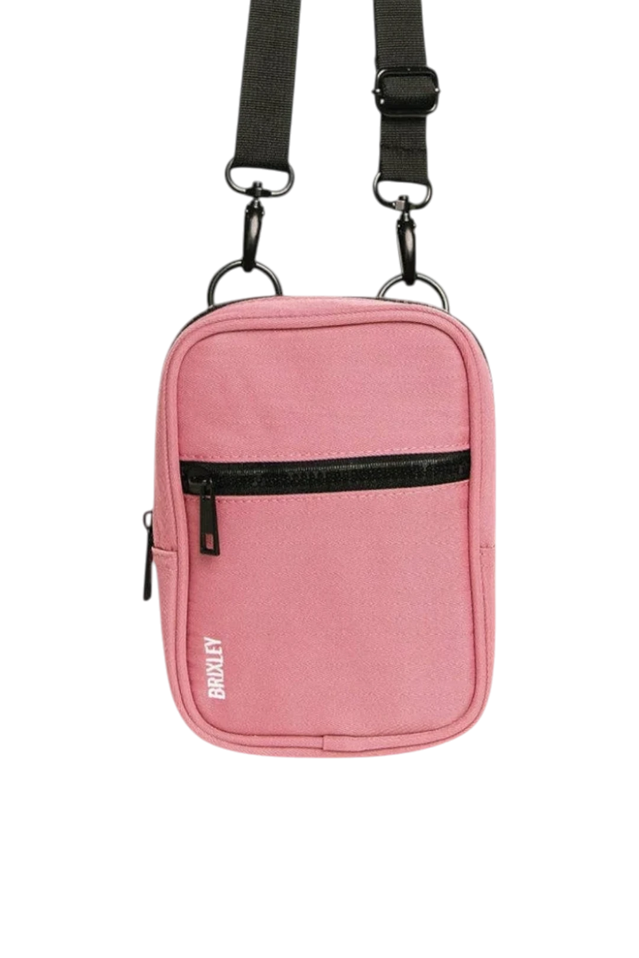 A pink Brixley crossbody phone bag with a black adjustable strap, black zipper, and white Briley logo on the front, shown against a plain white background.