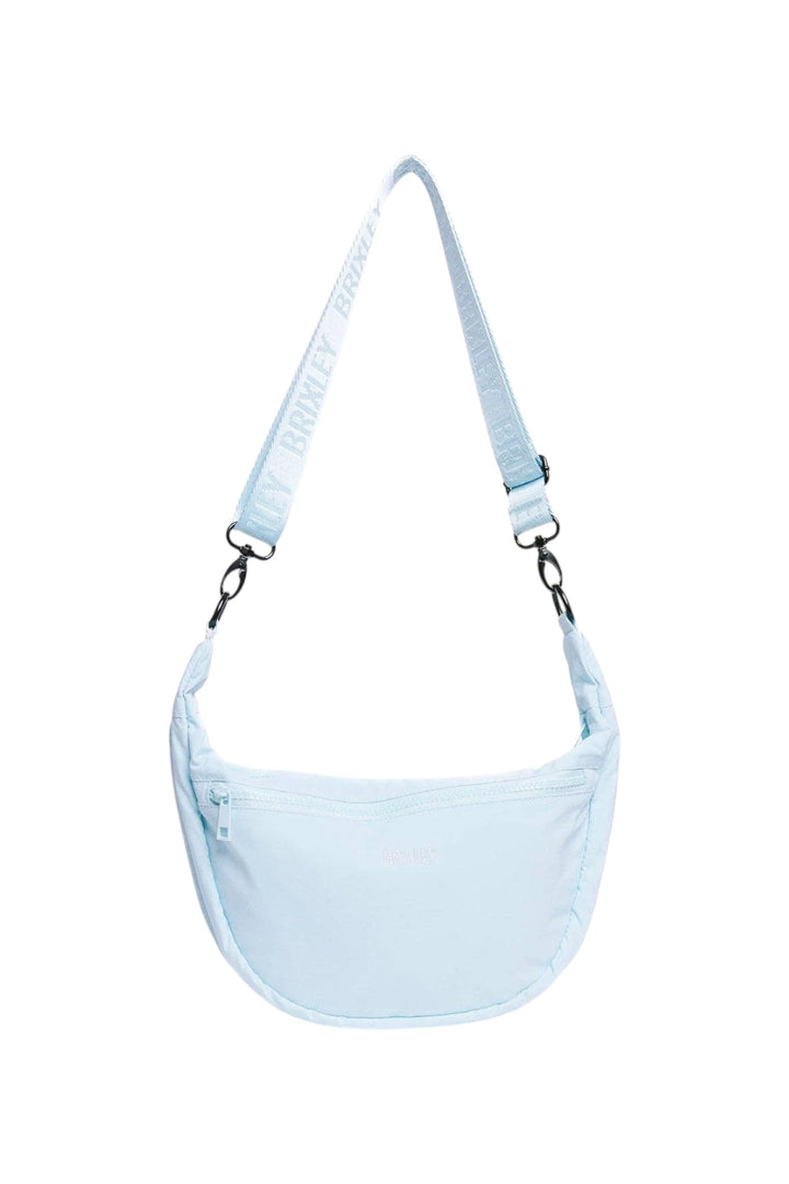 A light blue crescent-shaped shoulder bag with a matching adjustable strap featuring the brand name 'Brixley' printed in white, shown against a plain white background.
