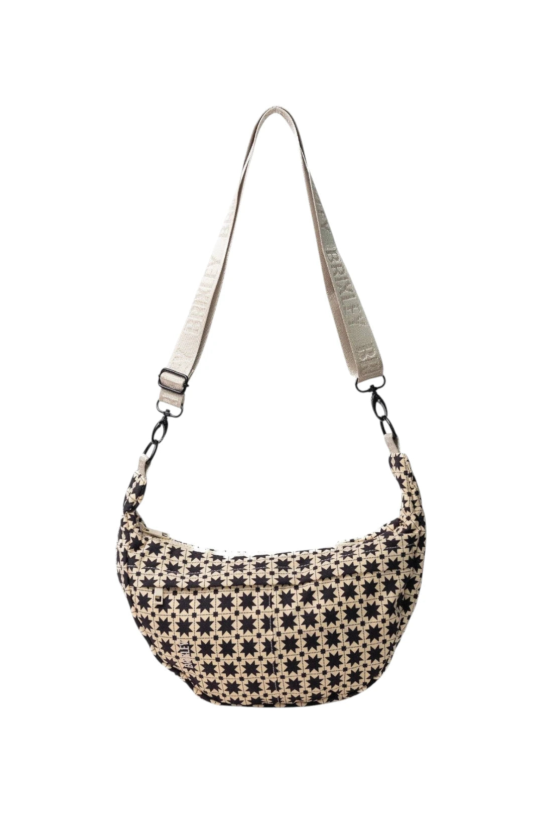 A crescent-shaped shoulder bag with a black and beige geometric star pattern, featuring a light beige adjustable shoulder strap with 'BRIXLEY' printed on it, shown against a plain white background.