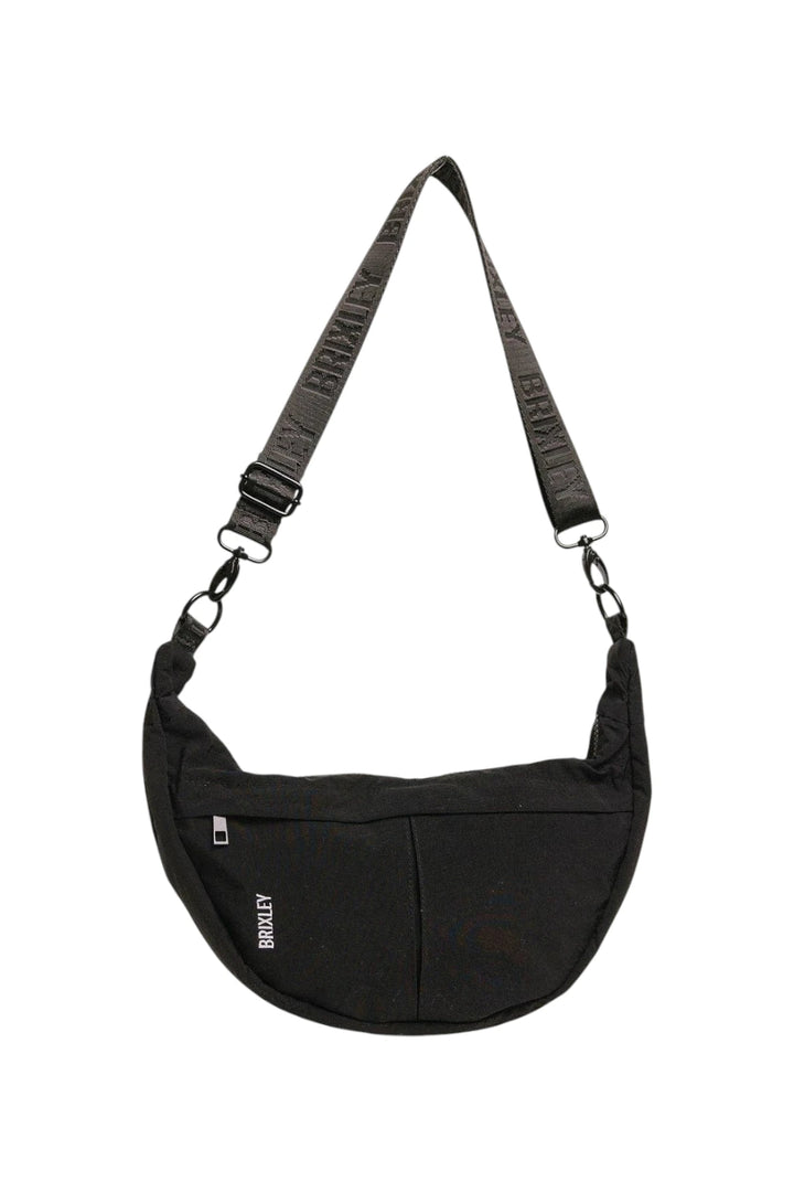 A black crescent-shaped shoulder bag with a wide, textured black strap and silver metal hardware, featuring a small white 'BRIXLEY' logo on the front.