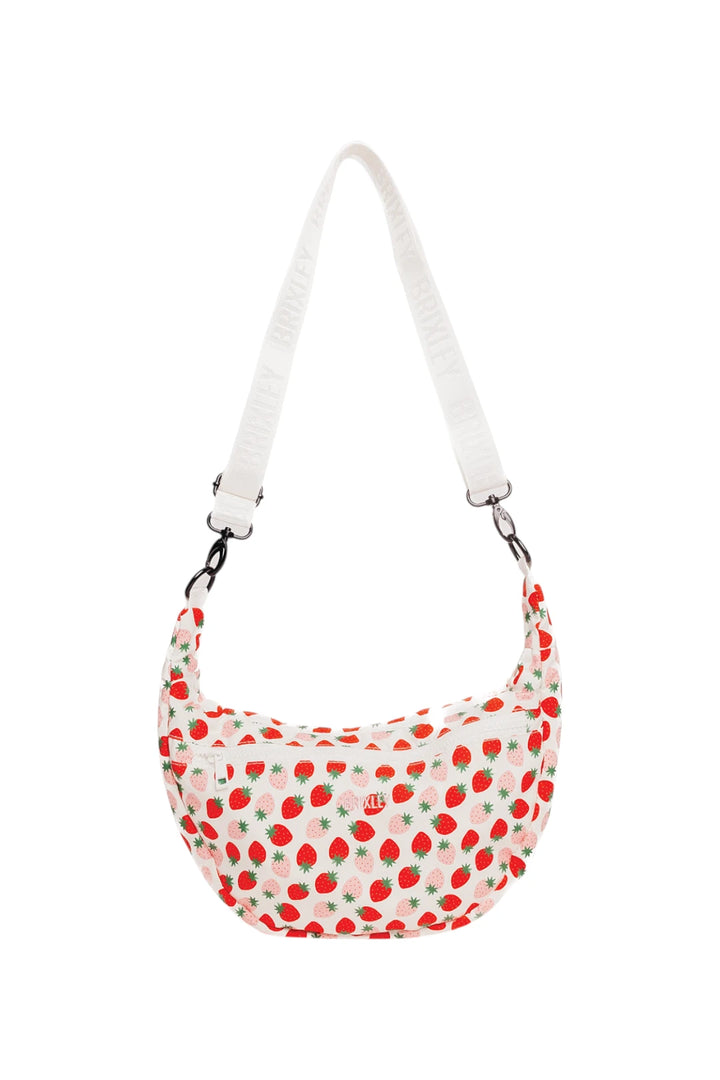 A crescent-shaped shoulder bag with a white strap and a white body covered in a red strawberry pattern, shown against a plain white background.