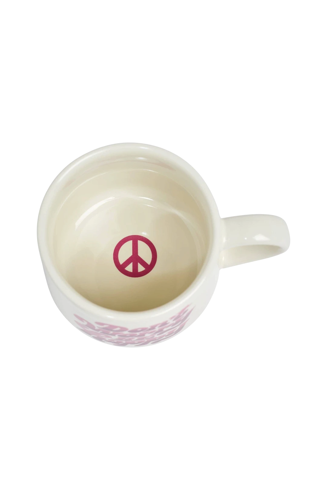 A white ceramic coffee mug viewed from above, featuring a pink peace sign printed inside the cup and a pink pattern around the lower exterior.
