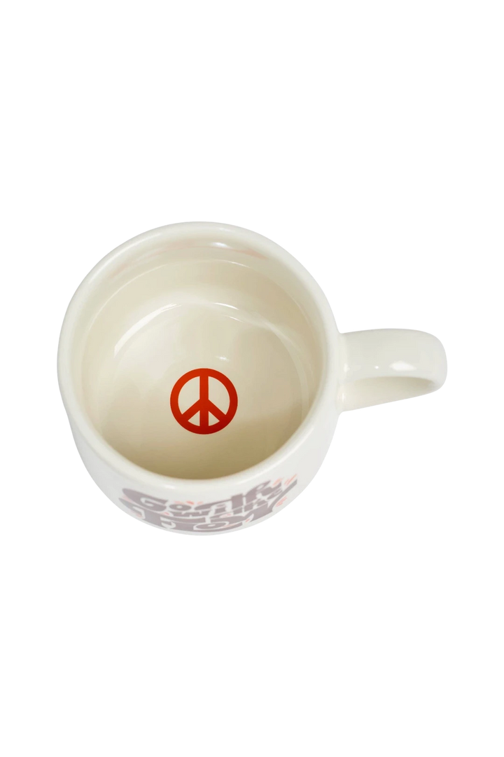 An off-white ceramic coffee mug shown from a top-down view, featuring a red peace sign printed inside the cup and a red and gray graphic on the side.